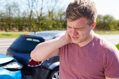 Man holding his neck in pain after a personal injury event (car accident).