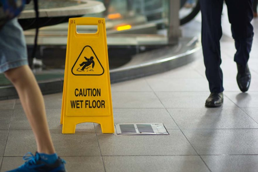 A business trying to prevent slip, trip and fall accidents with a caution sign.